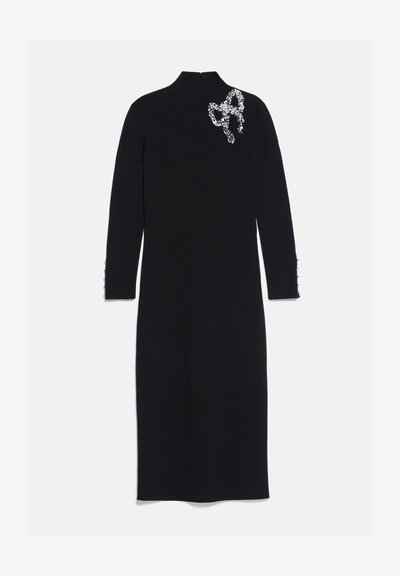 Robe midi noire à manches longues avec col haut et nœud décoratif en strass sur l'épaule gauche.