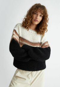 Maglione lavorato a maglia con un design a blocchi di colore crema, marrone e nero, con una vestibilità ampia e texture a costine sui polsini e sull'orlo.