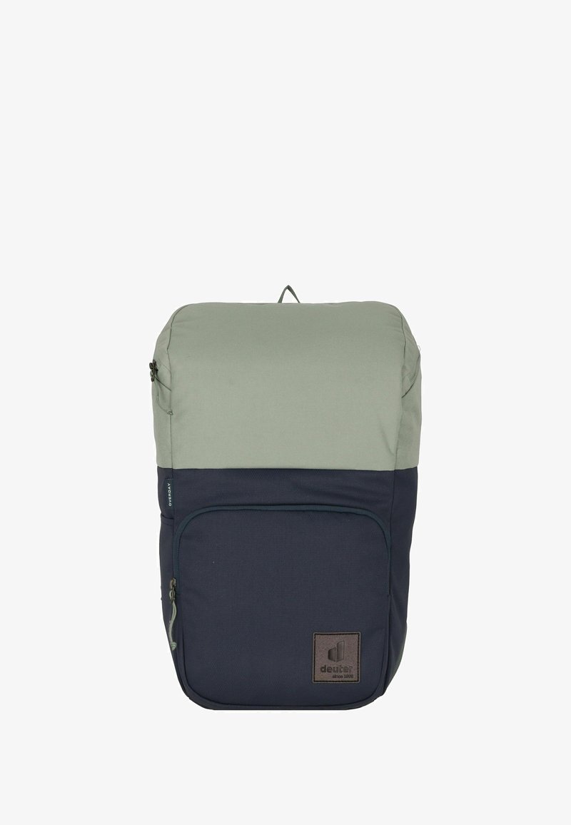 Zaino bicolore in verde oliva e blu navy con una tasca frontale con zip e un'etichetta in pelle nel angolo in basso a destra.