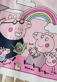 Varkenthema ontwerp op een roze achtergrond met personages die lezen en spelen, vergezeld van een regenboog en wolken, gedrukt in levendige kleuren.