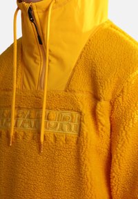 Yellow fleece pullover with high collar, half-zip design, and textured fabric. Features embroidered brand logo in matching color.
