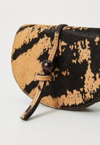 Borsa a busta con motivo, realizzata in pelle testurizzata nera e marrone chiaro, con forma curvilinea, dotata di chiusura a perla marrone rotonda e tracolla in pelle.