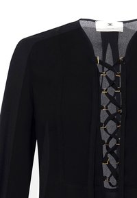 Prenda negra con un destacado diseño de cordones en la parte delantera y acentos de hardware dorado, hecha de tela suave y con una silueta estructurada.