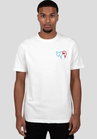 Camiseta de algodón blanca con un colorido logotipo bordado en el lado izquierdo del pecho, con cuello redondo y mangas cortas.