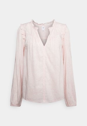 Lichtroze blouse met lange mouwen met een subtiel ruitpatroon, gerimpelde halslijn en schouders, en V-halsopening.