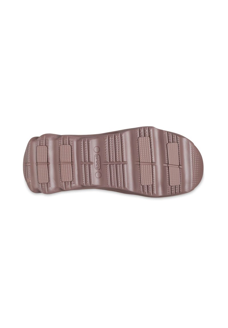 Braune Gummisohle mit strukturierten Grip-Mustern und Rillen, die drei flache Bereiche für Traktion und Komfort aufweisen.