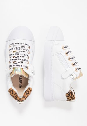 Scarpe da ginnastica bianche per bambino piccolo con tacco a stampa leopardata, lacci bianchi con scritte nere, linguetta olografica e cerniera laterale su sfondo bianco.