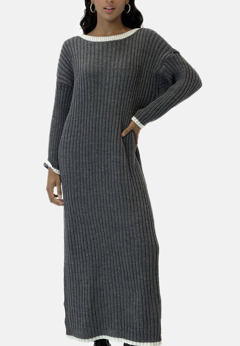 Vestido largo de punto acanalado gris con cuello redondo blanco y detalles en los puños, con mangas largas y bolsillos laterales. La tela texturizada parece suave.
