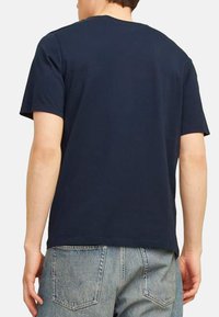 Navy blue cotton t-shirt with a crew neckline and short sleeves; displayed from the back, showing simple design and relaxed fit.