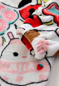 Coperta soffice con motivi colorati a tema cibo in tonalità vivaci. Il materiale è morbido e peloso, con trame evidenti e disegni giocosi.