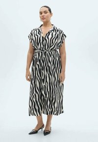 Rochie midi cu imprimeu alb și negru, cu mâneci scurte, guler și cordon la talie. Material neted cu o croială lejeră și un luciu subtil. Pantofi negri.