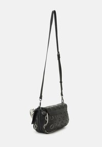 Borsa a tracolla in pelle nera con motivo floreale perforato, hardware argento, tracolla regolabile e chiusura con zip. Texture morbida e forma curva.