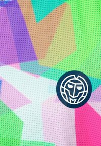 Tela con un patrón colorido que presenta formas geométricas en púrpura, verde y rosa, con un logo circular negro en la parte inferior.