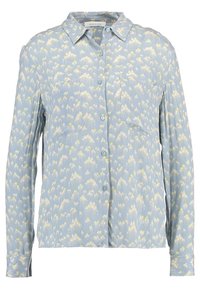 Camicia azzurro chiaro con bottoni, realizzata in un tessuto testurizzato, caratterizzata da un motivo floreale bianco e giallo, due tasche sul petto e maniche lunghe.