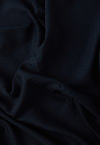 Sötét tengerészkék szövet texturált mintával, finom tónusbeli árnyalatokkal és sima, puha eséssel. Bútorhuzathoz vagy ruházathoz alkalmas.