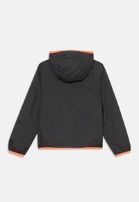 Veste noire avec une capuche, des poignets élastiques et une bordure orange vif le long de la capuche et de l'ourlet. Matériau lisse et léger.