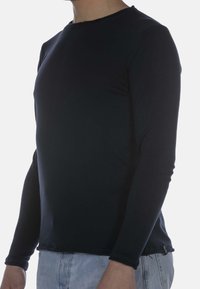 Langärmliges, marineblaues Hemd aus weichem Stoff mit Rundhalsausschnitt und leicht taillierter Form. Verfügt über einen genähten Saum und minimale Details.