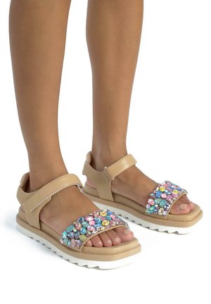 Beige sandals with a wide strap adorned with multicolored gems. Features a cushioned sole and ankle strap for secure fit. White sole.