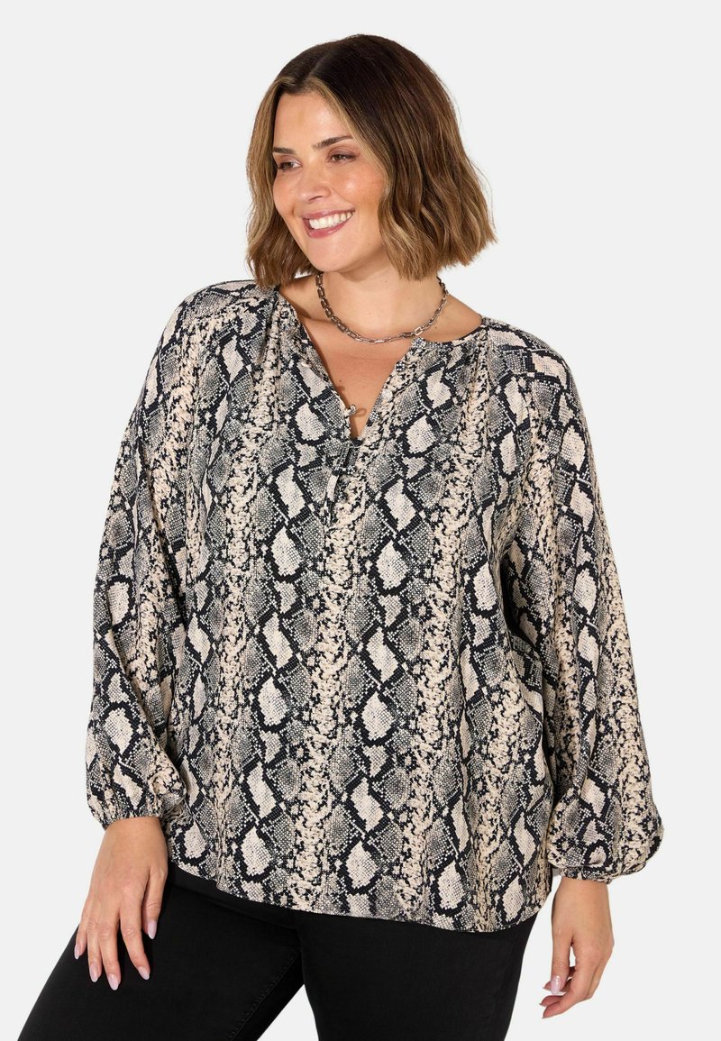 Blouse à manches longues en imprimé serpent beige et noir, avec un décolleté en V, une coupe ample et des manches resserrées. Tissu texturé avec un motif audacieux.