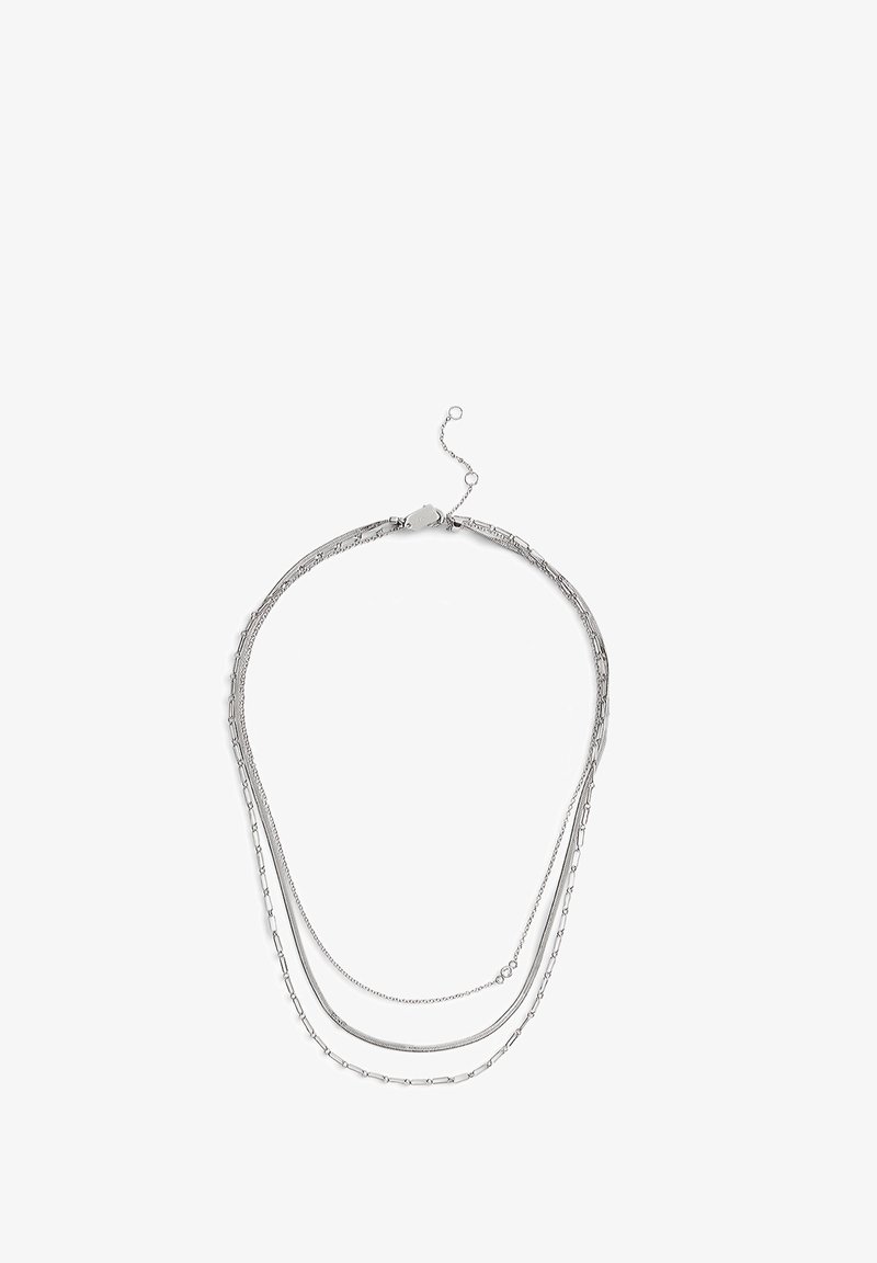 Collier en argent avec trois chaînes superposées ; largeurs et textures variées, comprenant des maillons ovales et carrés, fini par un fermoir et une chaînette d'extension.