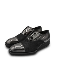 Schwarze Schuhe mit einer glänzenden Lackleder-Spitze und -Ferse, strukturiertem schwarzen Stoff in der Mittelpartie und einer niedrigen, flachen Sohle.