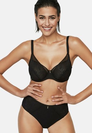 Ensemble de lingerie noire comprenant un soutien-gorge en dentelle avec armatures et bretelles réglables, associé à une culotte taille haute ornée de motifs subtils.