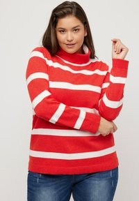 Röd polotröja med vita horisontella ränder, tillverkad av mjukt tyg, med långa ärmar och en avslappnad passform.