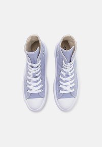 Zapatillas alta de lona en lavanda clara con puntera y suela de goma blanca, con cordones y costuras blancas. Interior liso.
