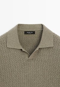 Pletený taupe polo svetr s texturovaným vzorem a žebrovaným límcem, uvnitř u krku s nápisem značky Massimo Dutti.