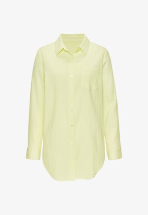 Chemise boutonnée à manches longues de couleur jaune pâle, avec un col pointu et une poche poitrine, fabriquée en tissu texturé léger.