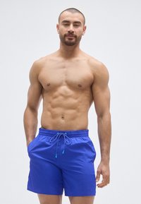 Μαγιό βερμούδα σε έντονο μπλε ύφασμα με ελαστική μέση και κορδόνι ρύθμισης. Διαθέτει πλαϊνές τσέπες και λείο, ελαφρύ ύφασμα.