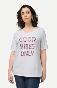 Camiseta de manga corta blanca con la frase "SOLO BUENAS VIBRAS" impresa en letras rojas, gruesas y a rayas. Material de algodón suave con un escote redondeado.