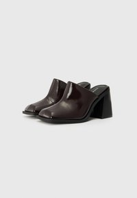 Bordeaux patentleren muiltjes met een afgeronde open neus, gesloten achterkant en een chunky zwarte hak. Gladde textuur met minimale stikseldetails.