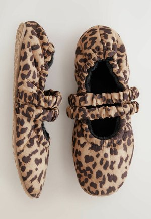 Hausschuhe mit Leopardenmuster, ausgestattet mit weichem Stoff, elastischen Kanten und einem schwarzen Kunstfellfutter. Flache Sohle mit strukturiertem Grip auf der Unterseite.