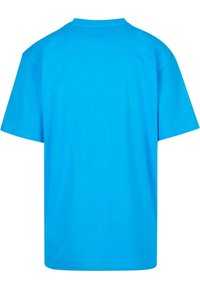 Īsu piedurkņu t-krekls spilgti zilā krāsā, izgatavots no gludas kokvilnas, ar klasisku apaļu kakla izgriezumu un brīvu piegriezumu, bez rakstiem vai rotājumiem.