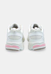 White mesh sneakers featuring a padded collar, contrast pink accents on the heel, and textured rubber sole for enhanced grip.