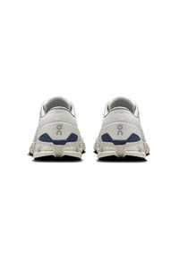 White and navy running shoes featuring a mesh upper, cushioned heel, and patterned sole for enhanced grip and support.