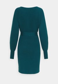 Vestito a maglia teal con maniche lunghe, texture a coste, vita aderente e orlo dritto. Design semplice senza motivi o accenti visibili.
