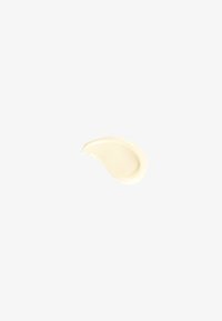 Produit cosmétique crémeux, de couleur blanc cassé, en forme de gouttelette courbée, avec une texture lisse et un léger éclat.