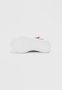 Sko såle med en hvit gummibase, med et strukturert diamantmønster og "Twinkle Toes" merkevare; fargerike aksenter på sidene.