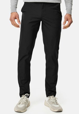 Pantalones negros, ajustados y confeccionados en material ligero, con una textura suave y un diseño clásico. Bolsillos frontales y forma de pierna recta.