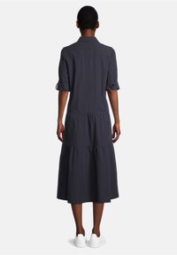 Tummanharmaa midi-mekko, jossa on lyhyet hihat, kaulus ja kerroksellinen hameosa. Valmistettu pehmeästä materiaalista, jossa on käännetyt hihansuut ja rento istuvuus.