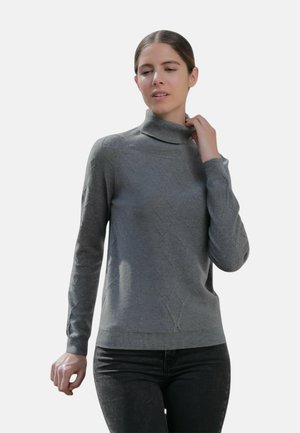 Pull en col roulé gris avec un motif de diamant texturé, poignets et ourlet côtelés, fabriqué à partir d'un matériau doux et léger. Associé à un jean foncé.