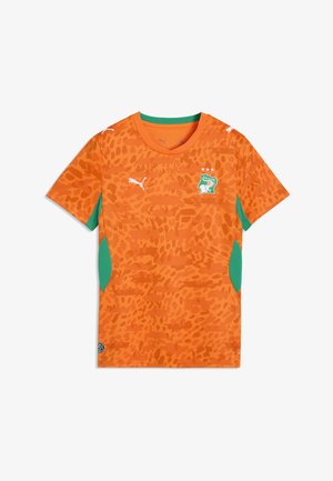 Camiseta de fútbol naranja con patrones abstractos, paneles laterales verdes, logos de Puma y escudo del equipo nacional de Costa de Marfil con tres estrellas.