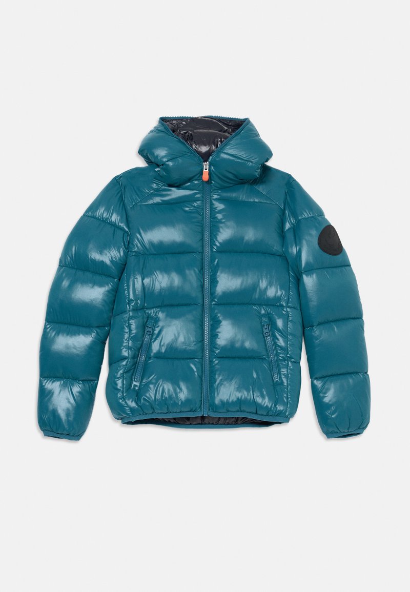 Giacca a vento teal con zip frontale, colletto alto e due tasche laterali. Presenta una patch del logo nera sul maniche sinistro e una texture lucida.
