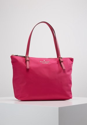 Klar pink Kate Spade New York shopper-taske med to håndtag, rektangulær bund og lynlås, vist på en hvid piedestal.