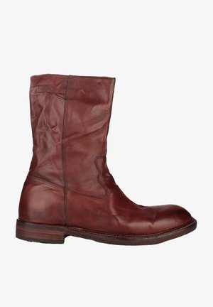 Botte en cuir brun montant mi-mollet avec bout arrondi, couture visible et petit talon en bois empilé, vue de côté extérieur.