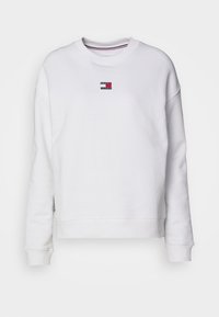 Felpa bianca a maniche lunghe con collo a giro e piccolo logo Tommy Jeans in rosso, bianco e blu centrato sul petto.