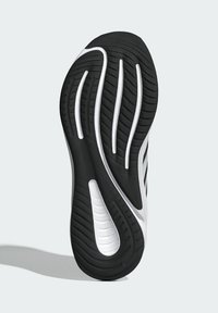 Black and white athletic shoe sole featuring textured rubber with grooves and ridges for grip, showcasing a curved design and flexibility.