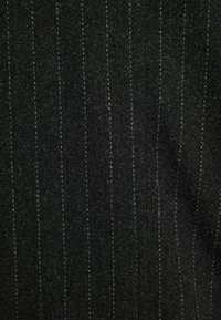 Tessuto nero con sottili strisce verticali grigio chiaro. Texture morbida, superficie leggermente spazzolata, con una leggera lucentezza.